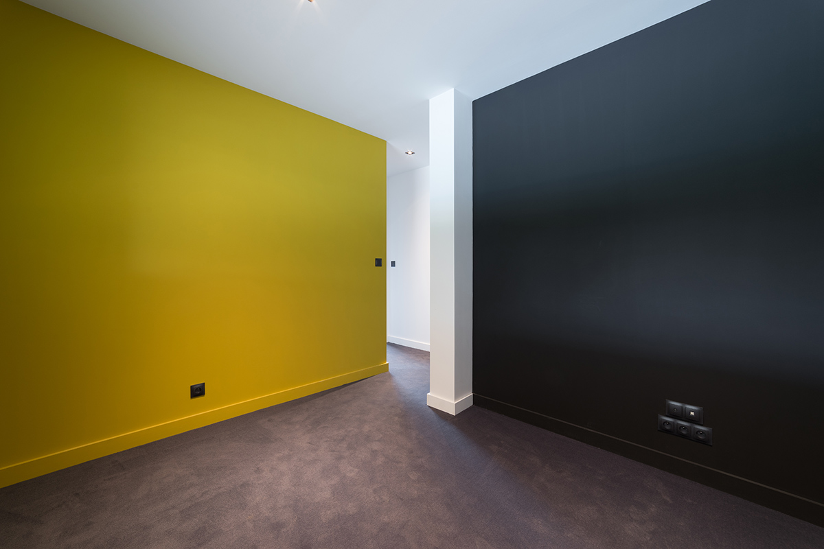 Une pièce aux murs jaune et noir, un contraste équilibré dans une maison très personnalisée