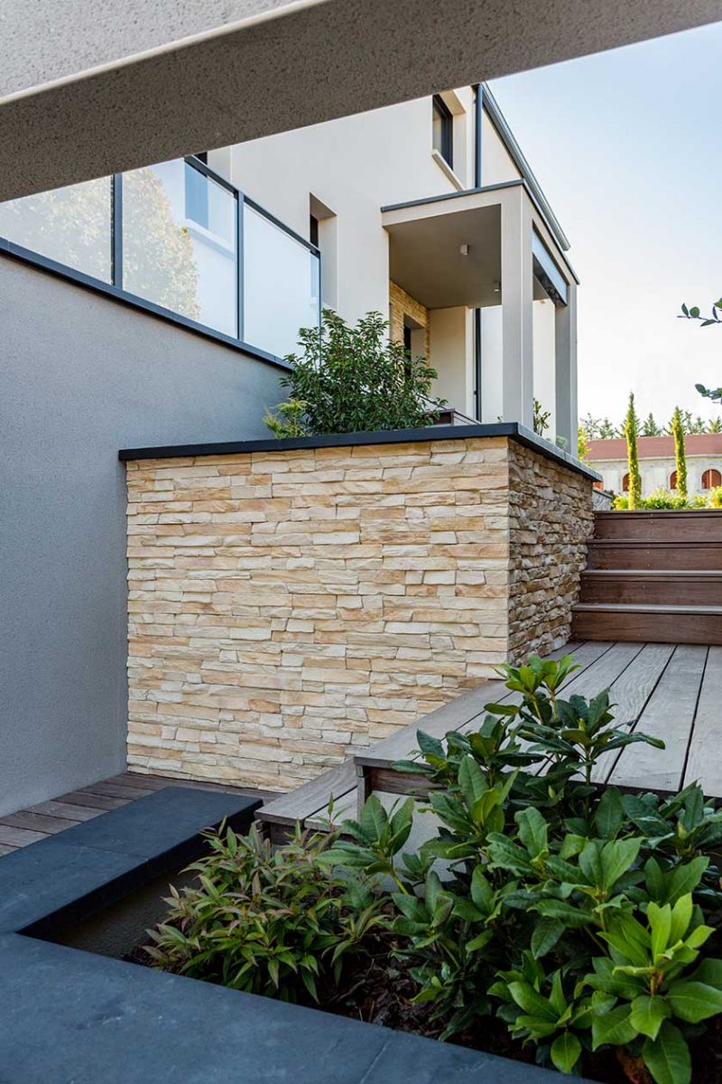 photo d'une allée exterieure avec muret en pierreee