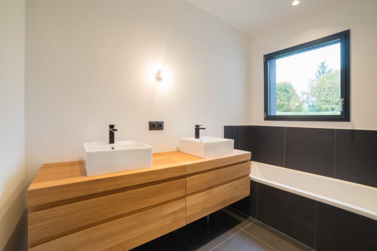 Salle de bain moderne et chaleureuse grâce au mariage du bois et de la faïence noire